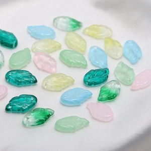 Detailed view of colorful glass leaf beads with realistic vein textures and top holes