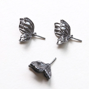 Détail de composants de bijoux ailes de papillon noires avec textures métalliques