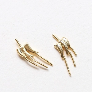Détail macro d'une paire d'accessoires de bijoux DIY en ailes de papillon dorées
