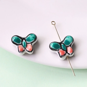 Vista macro di perle in ceramica dipinte a mano a forma di farfalla per gioielli DIY