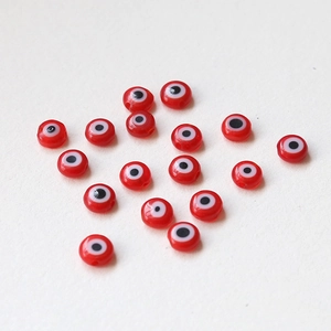 Close-up of red glass evil eye beads for handmade DIY jewelry and craft making