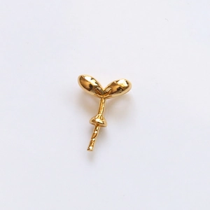 Detailed view of gold-plated sprout-shaped jewelry findings with polished leaf design