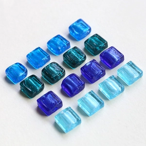 Macro shot of square translucent glass beads in various blue shades for DIY jewelry