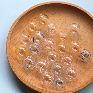 Macro shot of colorful spiral pattern inside transparent hollow glass beads in a wooden tray