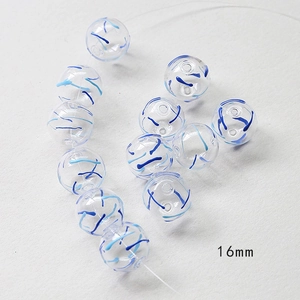 Macro shot of 16mm transparent hollow glass bead with blue spiral swirl pattern detail