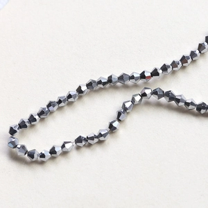 Macro shot of 4mm faceted bicone beads with dark grey metallic finish for DIY jewelry making
