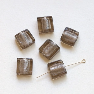 Macro detail of translucent square glass beads with silver foil foil and hole structure