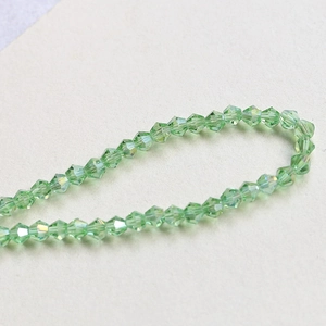 Close-up of 4mm faceted light green bicone crystal beads for DIY jewelry making