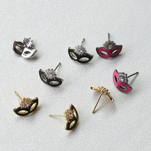 Detailed view of copper-plated gold masquerade mask charms with zircon inlays and enamel