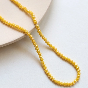 Macro shot of 3mm yellow faceted crystal beads for DIY jewelry and necklace crafting