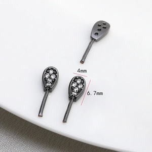 Macro detail of 4x6.7mm black nickel plated teardrop rabbit ear charm with cubic zirconia