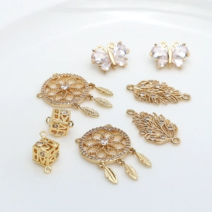 Detailed view of gold-plated brass dreamcatcher and butterfly charms with zircon inlays