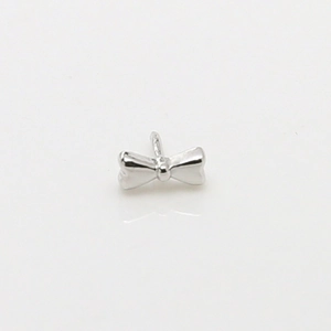 Detailed view of a silver bow-shaped metal pendant with a smooth mirror finish