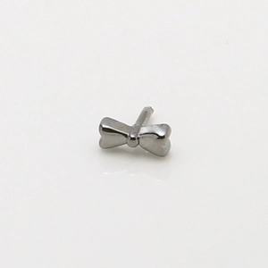 Macro detail of a silver bow-shaped DIY jewelry accessory with polished metal finish