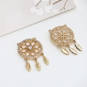 Detail of gold-plated dreamcatcher pendants with intricate filigree and cubic zirconia