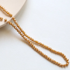 Macro detail of 3mm faceted champagne crystal spacer beads for DIY jewelry making