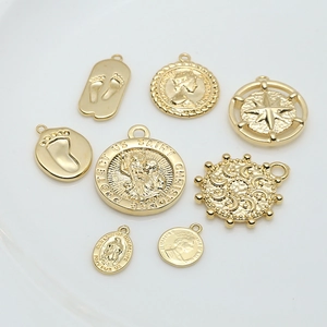 Detailed view of various vintage gold relief pendants for DIY jewelry and earrings