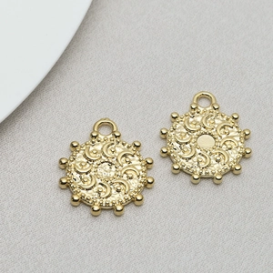 Detail of round gold pendant charms with sun and moon relief for DIY jewelry making