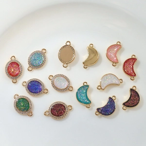 Detail of gold-plated oval and moon pendants with micro-inlaid zircon and colorful glitter