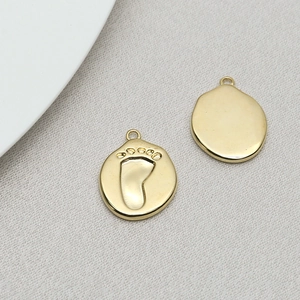 Detailed view of gold baby footprint charms for handmade jewelry and necklaces