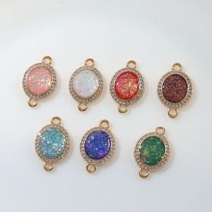 Macro detail of oval moon pendants with sparkling resin centers and zircon accents