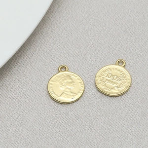 Detailed macro view of vintage gold coin pendants with 3D embossed portraits and inscriptions