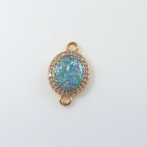 Macro detail of gold oval moon pendant with opal center and zircon micro-pave setting