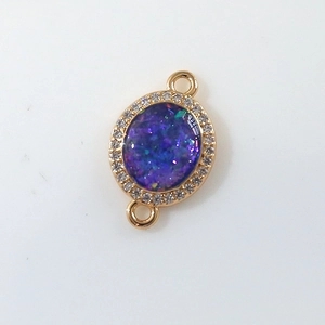 Detailed macro view of oval gold-plated pendant with purple opal and zircon accents