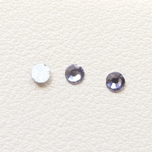 Makro-Detail von facettierten Kristallaugen in Violett und Silber für DIY-Schmuck