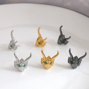 Macro shot of 18K gold plated dragon stud earrings with green zircon eyes details