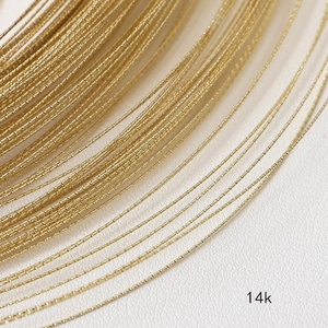 Vista macro de alambre de cobre trenzado bañado en oro de 14k con acabado facetado