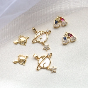 Macro shot of gold-plated celestial charms with shell inlay and colorful cubic zirconia