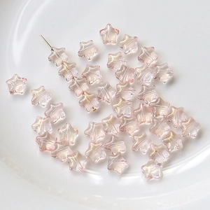 Gros plan de perles d'étoile en verre rose 8mm avec paillettes dorées pour bijoux