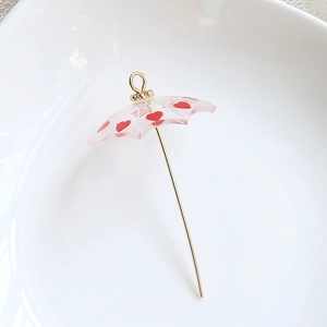 Detail of DIY umbrella pendant with red hearts and golden handle for jewelry making