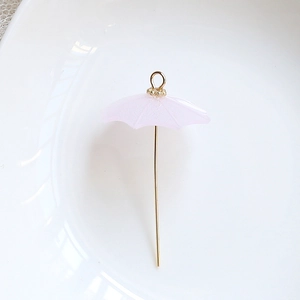 Detailed view of a mini pink umbrella charm with gold-plated handle for DIY jewelry