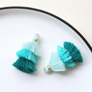 Nahaufnahme von dreistufigen blauen Quasten mit Goldring für DIY-Schmuckherstellung