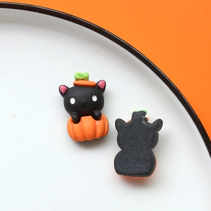Dettaglio di ciondoli in resina di Halloween con gatto nero nella zucca per fai da te