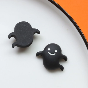 Vista macro di ciondoli in resina a fantasma nero con faccine bianche per accessori fai da te