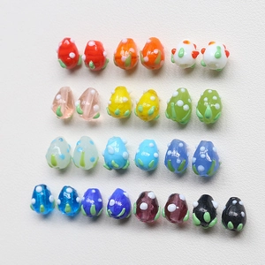 Vue détaillée de perles en verre colorées en forme de fraise pour la création de bijoux