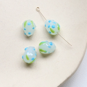 Détail de perles en verre faites main avec points bleus et rayures pour bijoux DIY