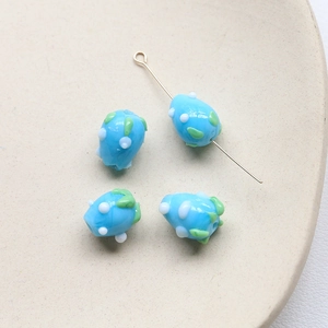 Vue détaillée des perles en verre bleu ciel avec fleurs pour la création de bijoux DIY
