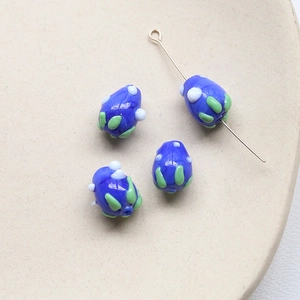 Détails de perles de verre bleues en forme de goutte avec des motifs de points variés