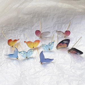 Gradient resin butterfly and fish tail stud earrings with gold pins on lace fabric