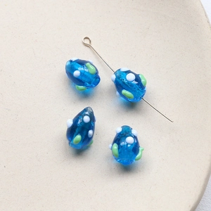 Détail de perles en verre bleues faites main avec points blancs pour bijoux DIY