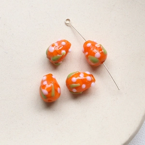 Vue macro de perles en verre fruit du dragon pour bijoux DIY avec pois orange vif et roses