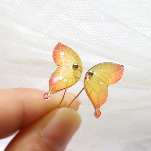 Close-up of orange gradient resin butterfly wings with glitter for DIY jewelry