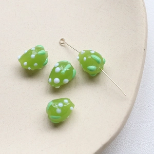 Gros plan de perles en verre fraise verte avec points blancs pour bijoux faits main
