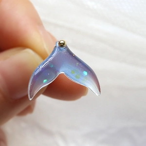 Macro shot of a resin gradient whale tail pendant with glitter and golden bead