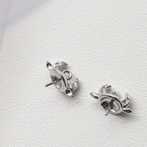 Détail d'apprêts bijoux corne argentée avec zircons blancs et tige de montage pour perle