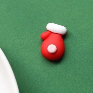 Close-up of red resin Christmas glove charm for DIY hair clips and crafts